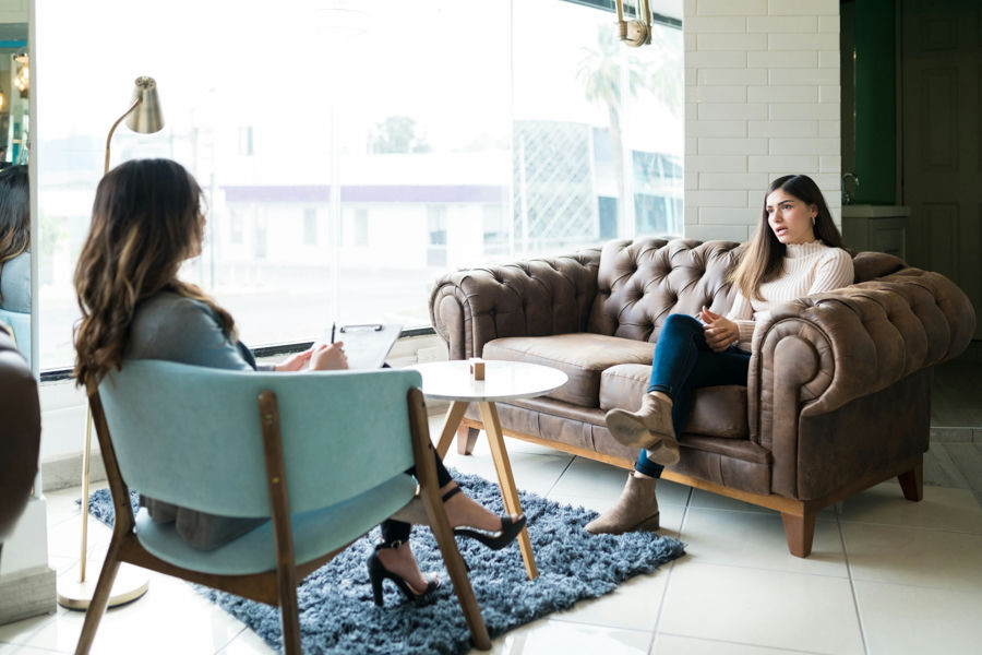 woman sitting on couch talking to a therapist