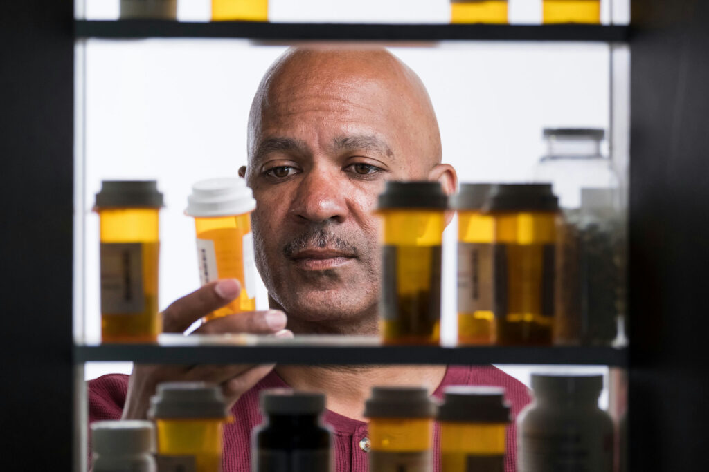 a-man-picking-up-a-bottle-of-pills-from-the-medicine-cabinet