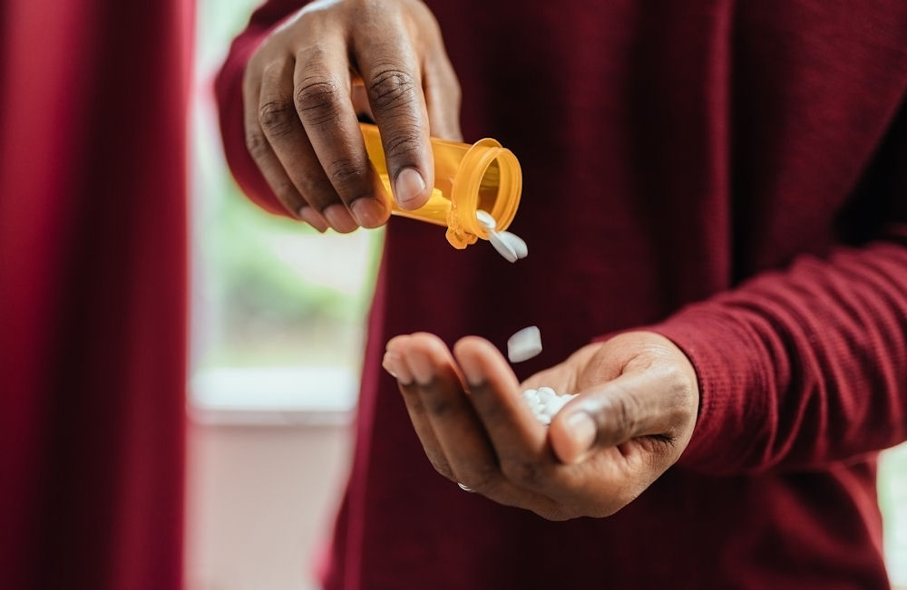 a-man-pouring-out-opioids-from-a-pill-bottle-into-his-hand