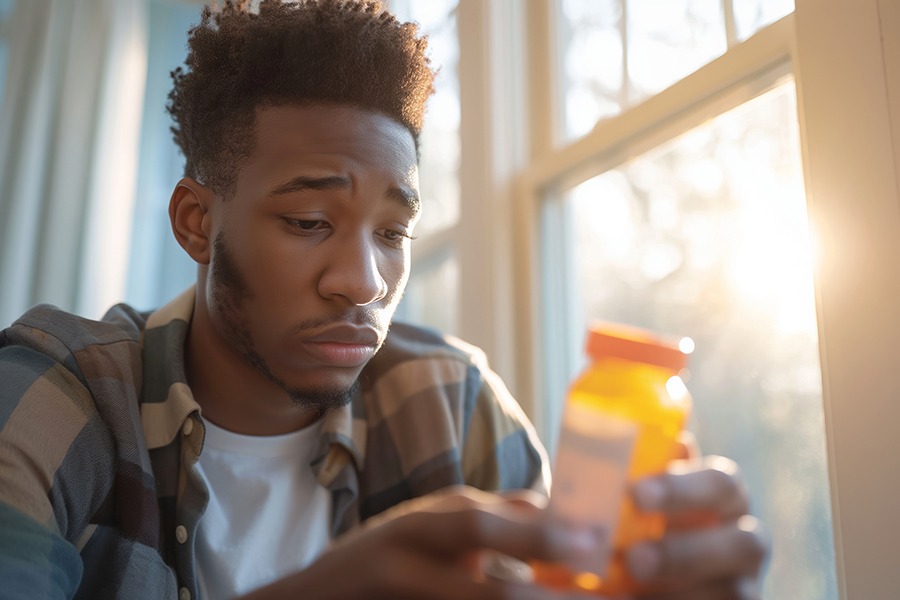 a-man-staring-at-a-pill-bottle