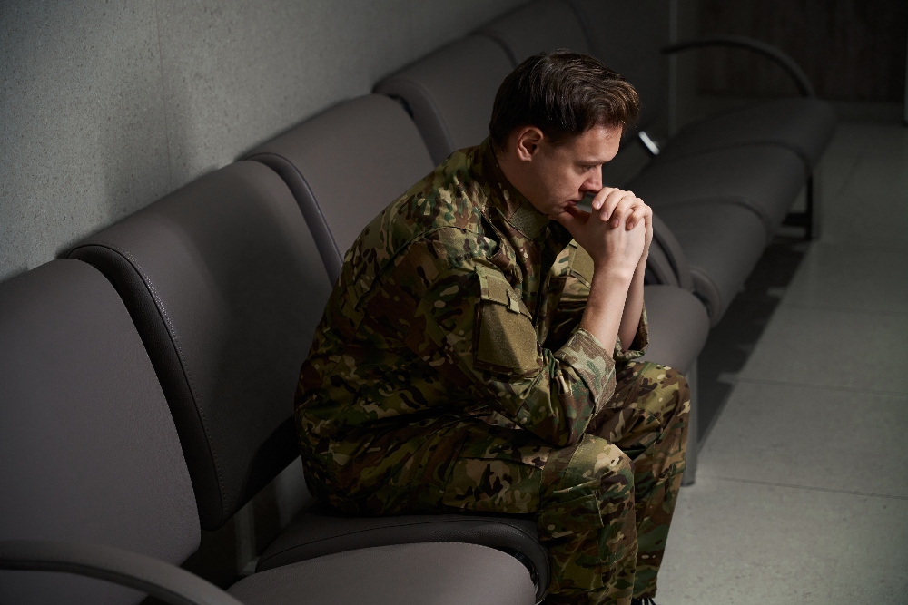 veteran man in uniform sitting on couch struggling with mental health and substance abuse