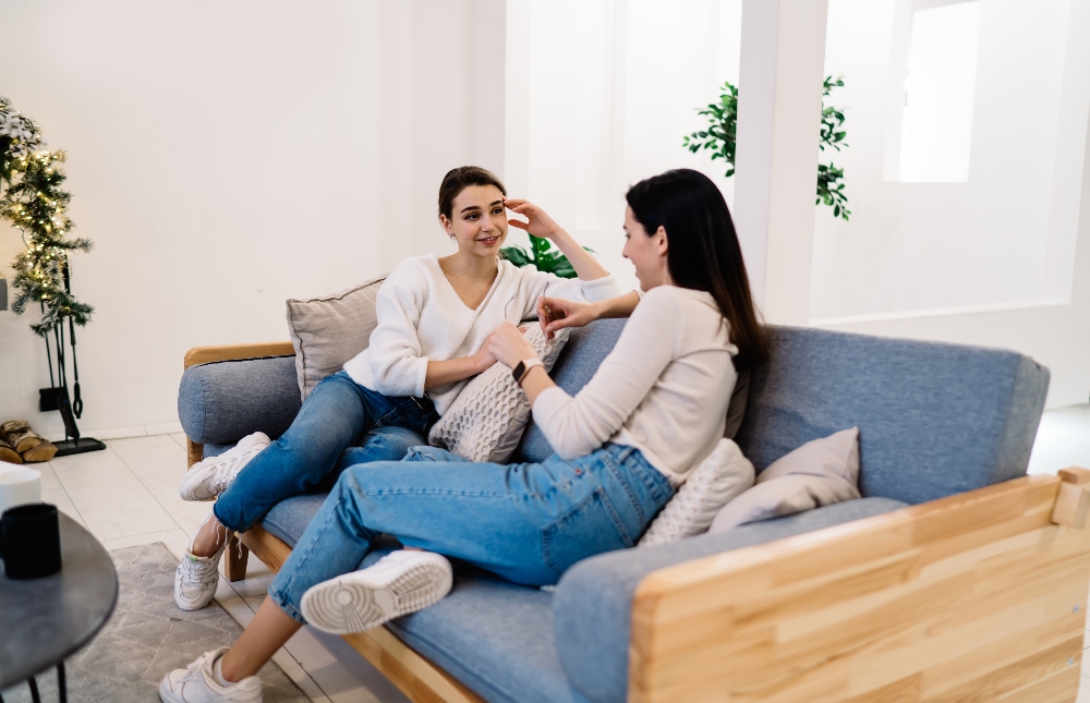 friends sitting on couch together talking
